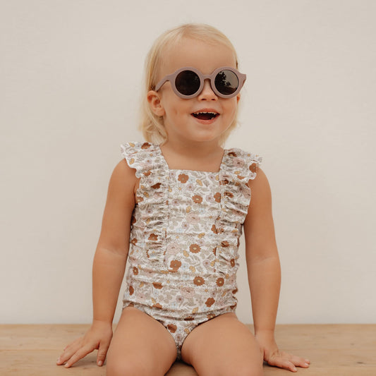 Little Girl Wearing The Little Dutch Short Sleeved Swimming Costume In Vintage Little Flowers Print