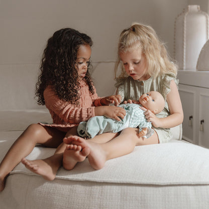 Little girls putting on the little dutch baby doll outfit to the Lily baby Doll