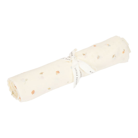 Muslin swaddle tied with a ribbon, decorated with mushrooms, acorns and other forest elements