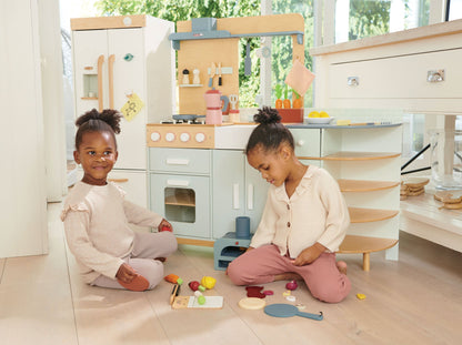 children playing with toy kitchen